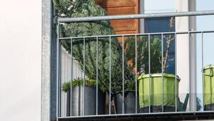 Weihnachtsbaum steht in einem Eimer auf einem Balkon