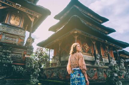 Frau läuft durch balinesischen Tempel.