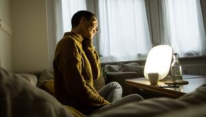 Frau sitzt vor einer Tageslichtlampe