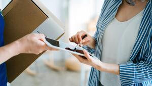 Frau nimmt Paket per Unterschrift an