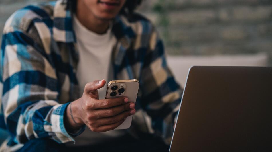 Ein Mann hält ein Iphone in der Hand