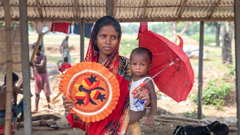 Eine Mutter in Bangladesch mit ihrem Kleinkind auf dem Arm während einer Hitzewelle im Mai 2024.