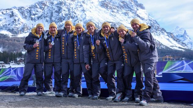 Acht deutsche Bobfahrer feiern ihren Doppelsieg im Viererbob.