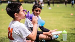 Junge trinkt Wasser am Sportplatz