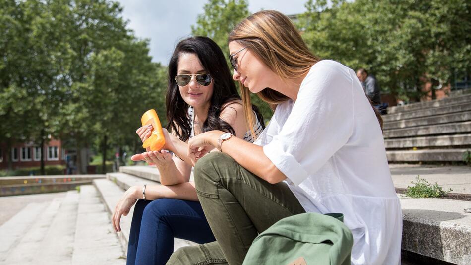 Zwei Frauen benutzen Sonnencreme