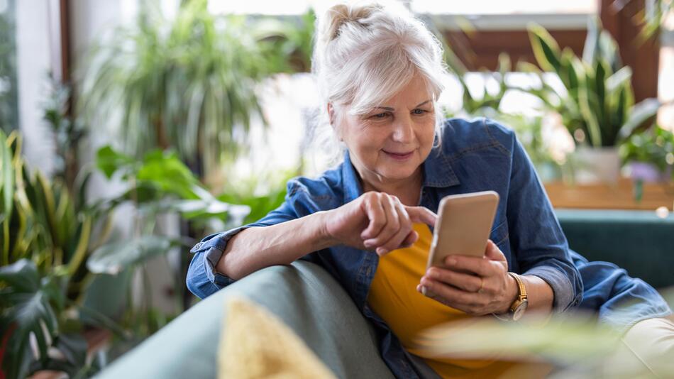 Seniorin ist am Handy und lächelt