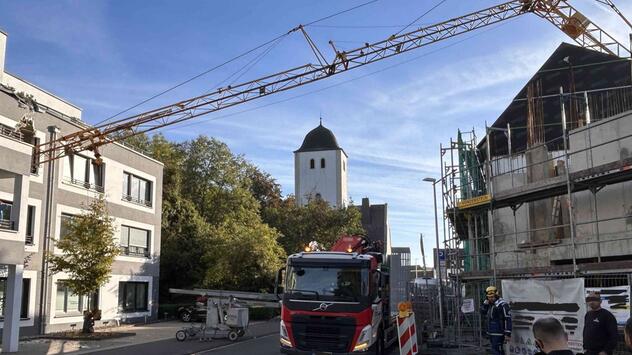 Kran kippt und stürzt auf Wohnhaus