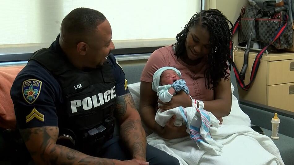 Polizist mit Mutter und Baby, das er auf die Welt geholt hat