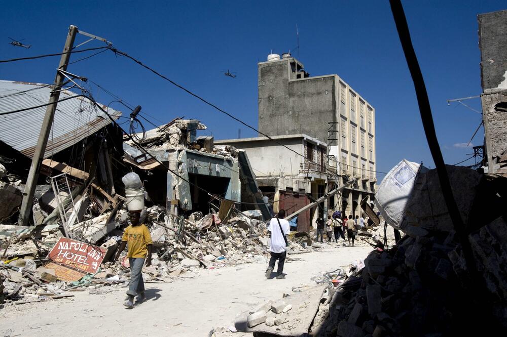Menschen, die nach dem Erdbeben in Haiti, an zerstörten Gebäuden vorbeigehen