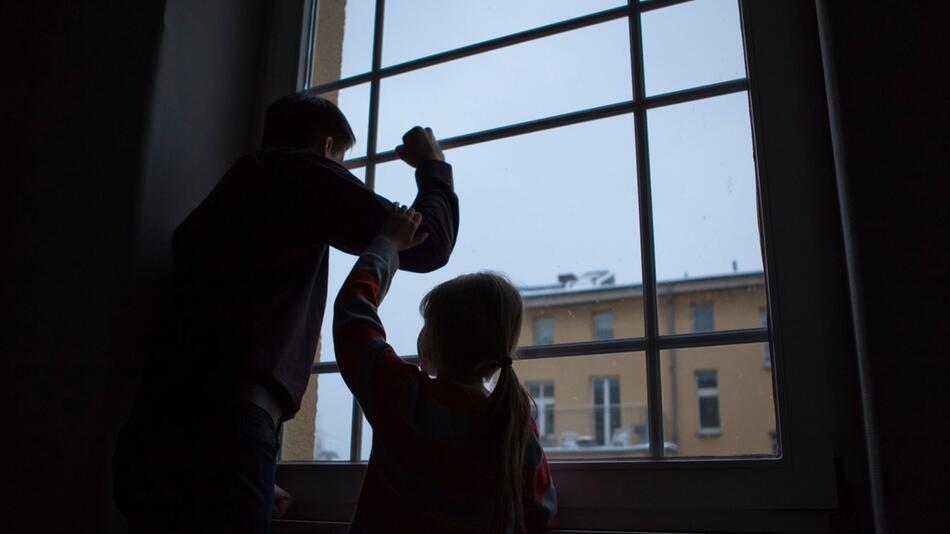 Erwachsener und Kind stehen an einem Fenster