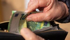 Eine Seniorin steckt Euro-Banknoten in eine Geldbörse