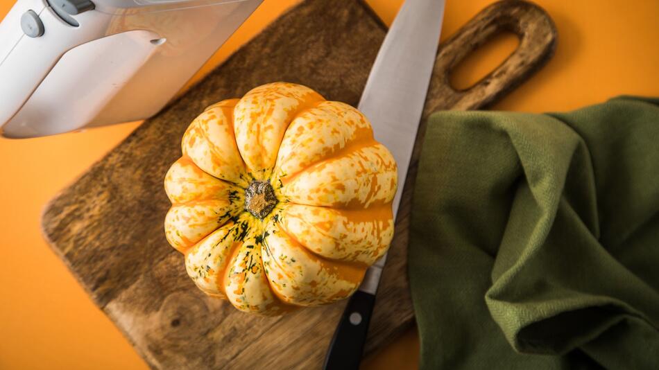 Utensilien, um einen Kürbis mit einem Handmixer auszuhöhlen