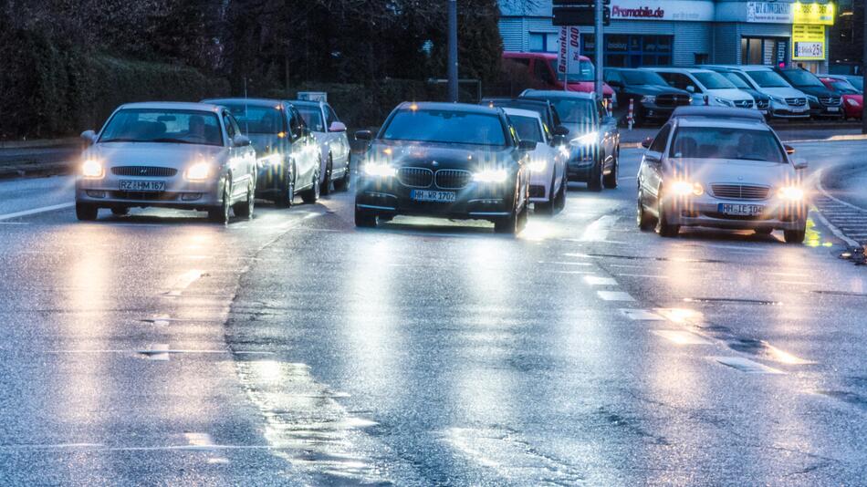 Autos stehen in der Abenddämmerung an der roten Ampel