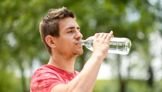 Mann trinkt aus einer Wasserflasche