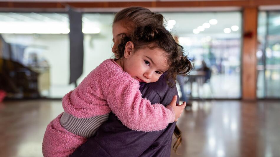 Ein kleines Mädchen auf dem Arm der Schwester