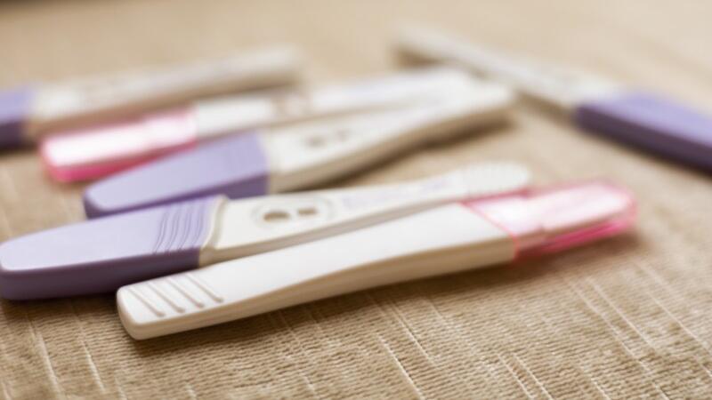 Sechs Schwangerschaftstest liegen auf dem Tisch.