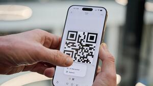 Ein Mann drückt auf einen QR-Code auf einem iPhone