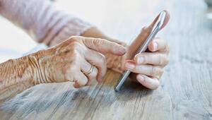 Hände einer Seniorin, die auf einem Smartphone tippt