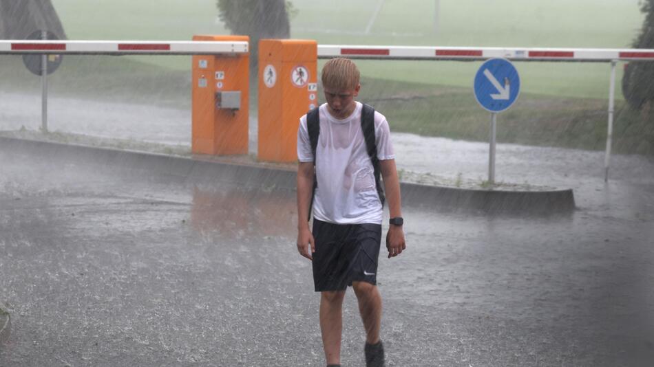 Ein junger Hertha-Fan läuft am 26. Juni 2023 enttäuscht durch das Gewitter am Trainingsgelände