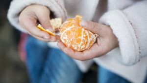 Mädchen schält eine Mandarine