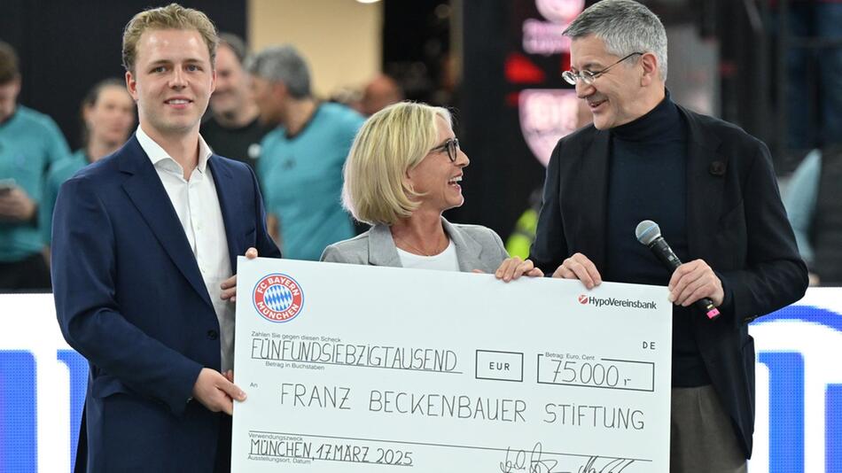 FCB-Präsident Herbert Hainer (70) überreicht Joel und Heidi Beckenbauer einen Scheck für die ...