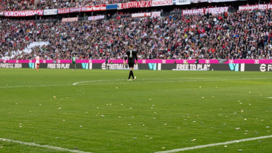 Bayern-Torwart Manuel Neuer spaziert an seinem von Schokoladentalern übersäten Strafraum entlang