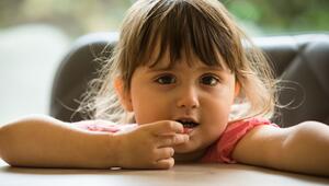 Ein Mädchen steckt sich etwas in den Mund