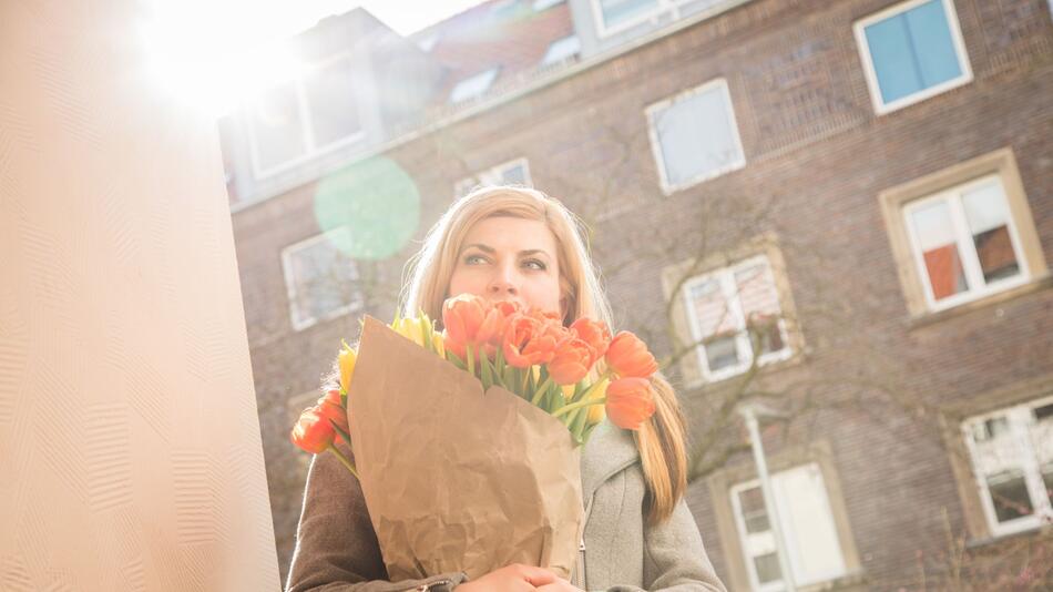 Eine Frau bringt Tulpen mit