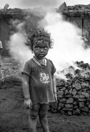 Kleine Kinder vor brennender Kohle