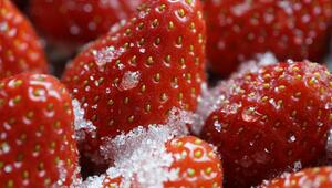 Nahaufnahme von roten Erdbeeren, die mit grobkörnigem Zucker bestreut sind.