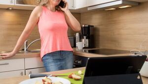Eine Frau führt ein Telefonat in der Küche