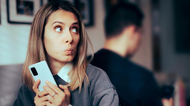 Ertappt schauende Frau mit dem Rücken zu einem Mann
