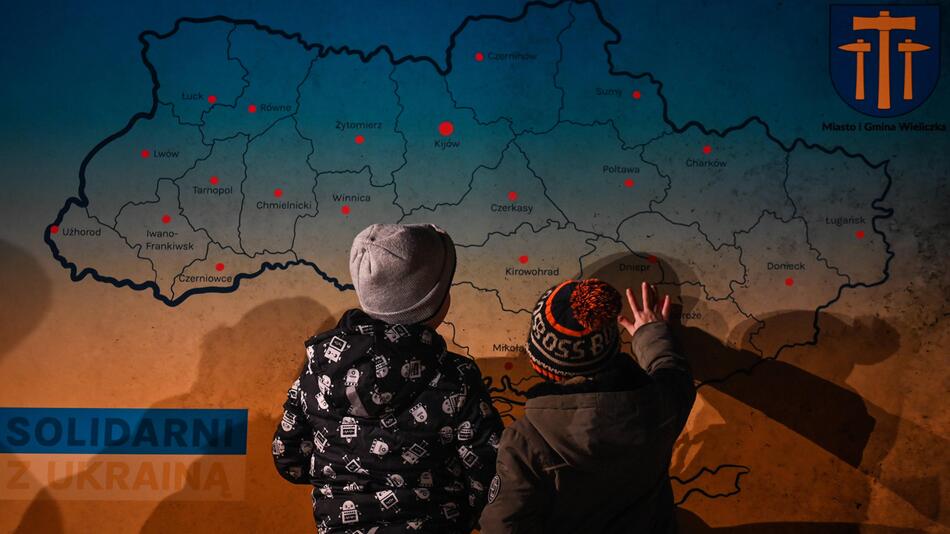 Kinder betrachten in Polen eine Karte der Ukraine