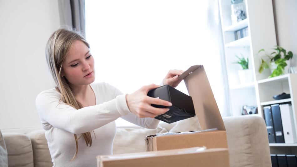 Eine Frau öffnet ein Paket