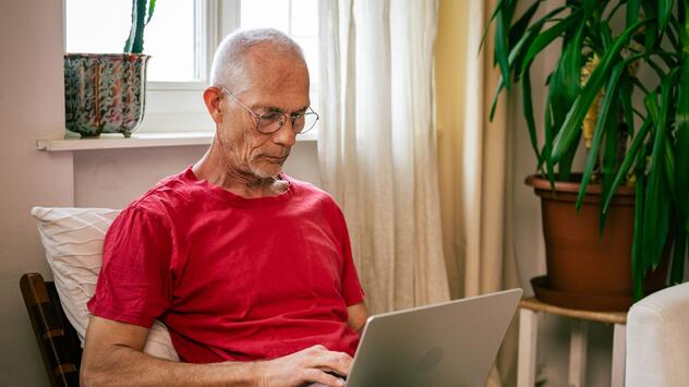 Mann schaut auf einen Laptop