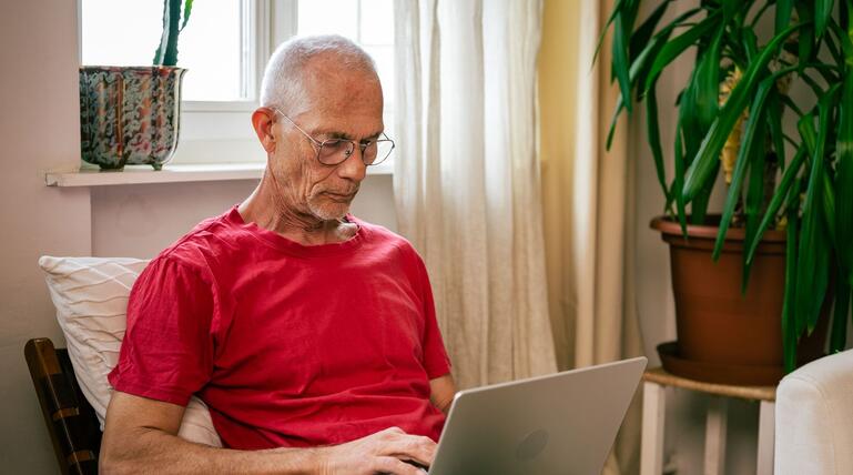 Mann schaut auf einen Laptop