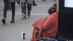 Obdachlose Person sitzt auf der Straße