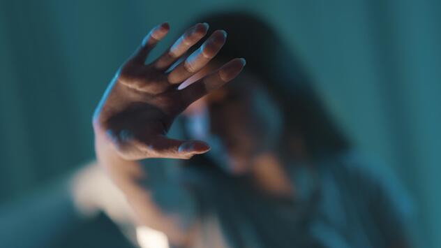 Frau streckt ihre Hand als Zeichen für "Stop" nach vorne