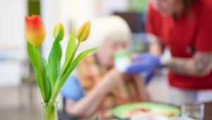 Eine Pflegekraft unterstützt eine Seniorin