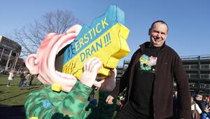 Jacques Tilly steht neben seiner Figur, die Putin zeigt, wie er an der Ukraine erstickt.