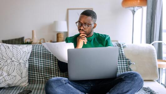 Mann sitzt am Laptop