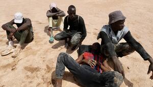 Migranten sitzen in der tunesische Wüste