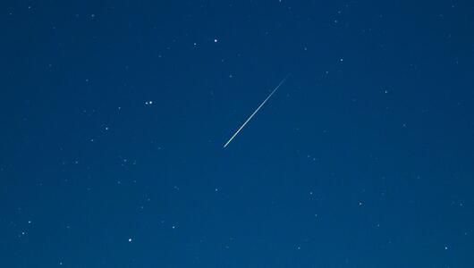 Eine Sternschnuppe leuchtet am Nachthimmel 