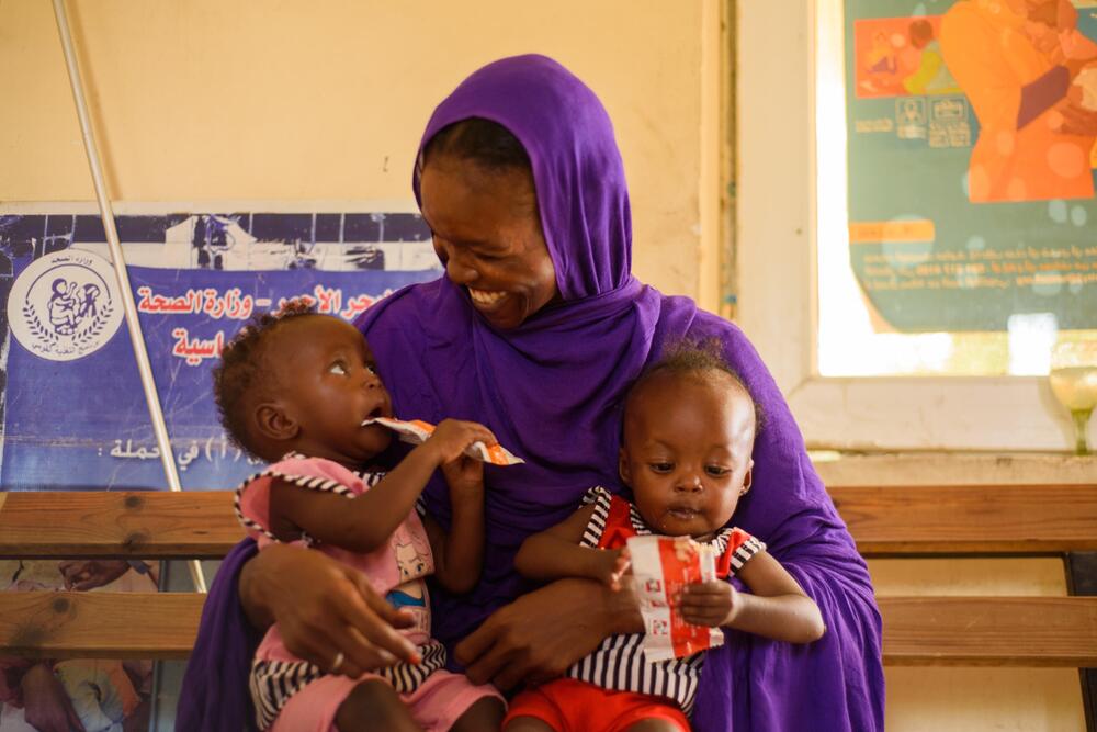 Eine Mutter mit ihren Zwillingen im Sudan