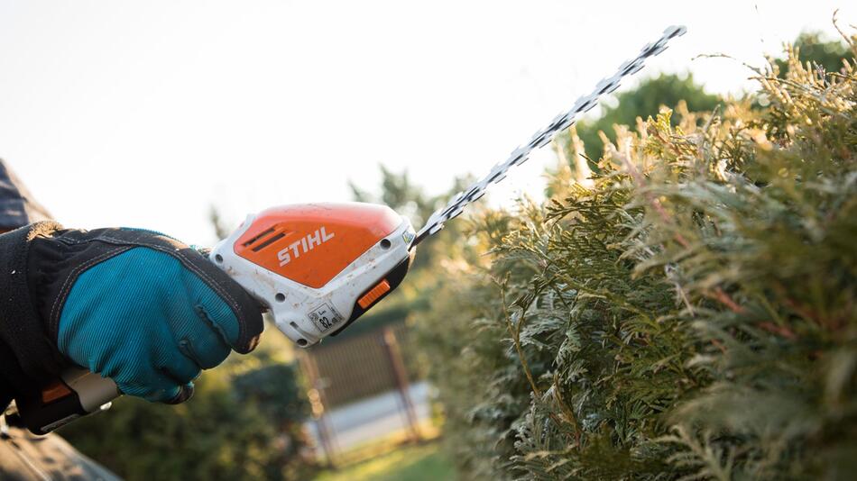 Hecke wird mit einer Einhand-Heckenschere geschnitten
