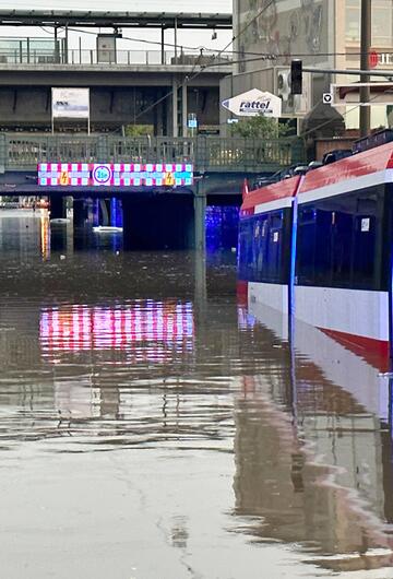 Eine Straßenbahn in einer überfluteten Unterführung.