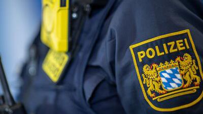 Eine Polizistin trägt ein Abzeichen der bayerischen Polizei.