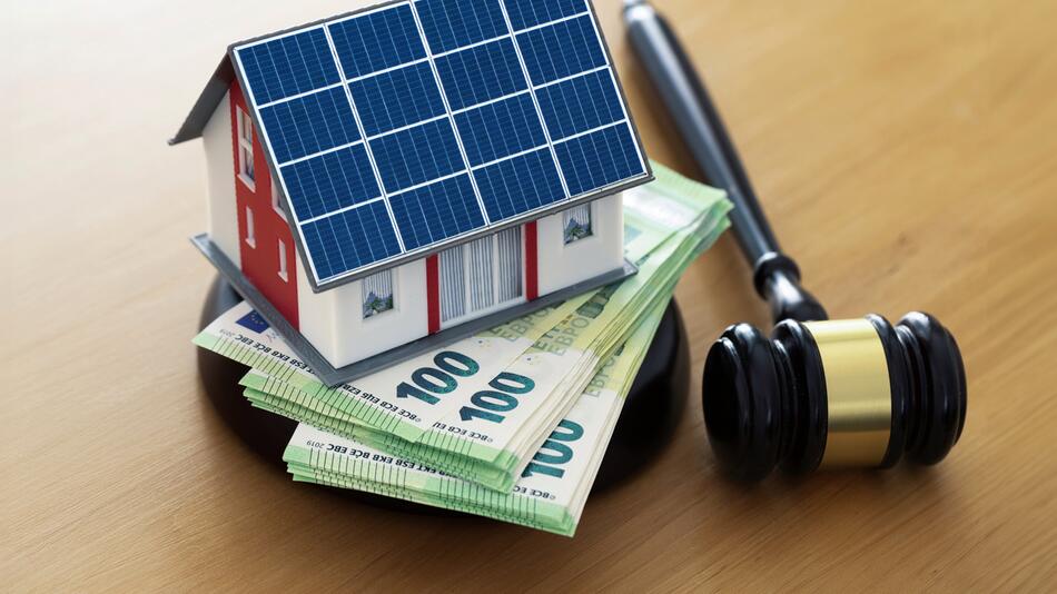 Ein Spielzeug-Solar-Haus steht auf Geldscheinen, daneben ein Richterhammer