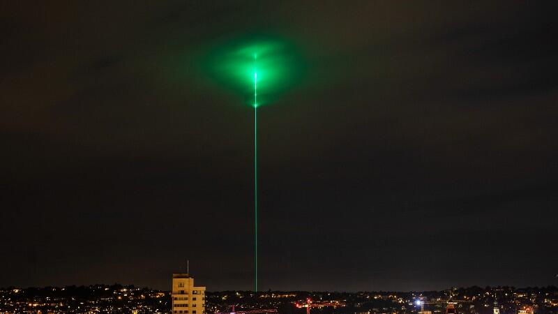 Ein Laserstrahl leuchtet über eine Stadt.