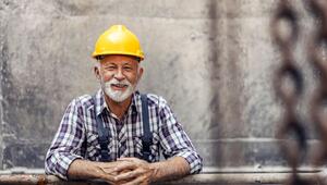 Foto eines Seniors, der in einer Fabrik arbeitet.